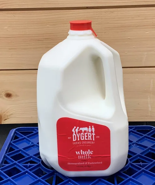 Whole milk jug from Dygert Farms Creamery, labeled and featuring a red cap, placed on a blue plastic crate with a wooden background.