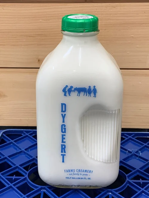 Half-gallon bottle of Dygert Farms Creamery milk with a green cap, featuring a blue logo and graphic of children interacting with a cow, set against a blue crate background.