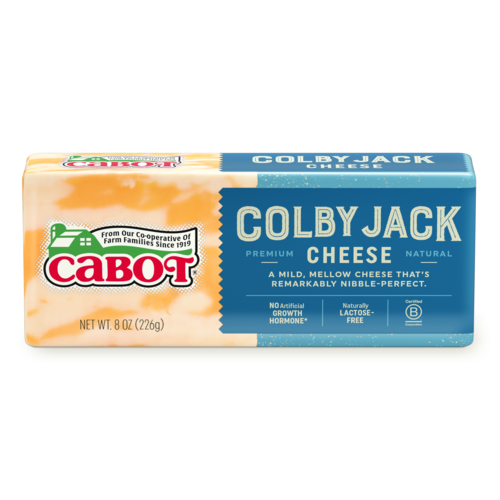 Block of Cabot Colby Jack cheese, 8 oz package, featuring a blend of mild and mellow flavors, labeled as natural cheese, lactose-free, and free from artificial growth hormones. Ideal for snacking and cooking.